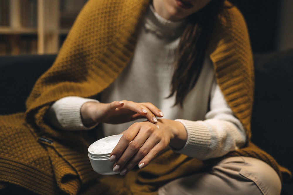 Девушка ухаживает за руками, мажет кремом для рук