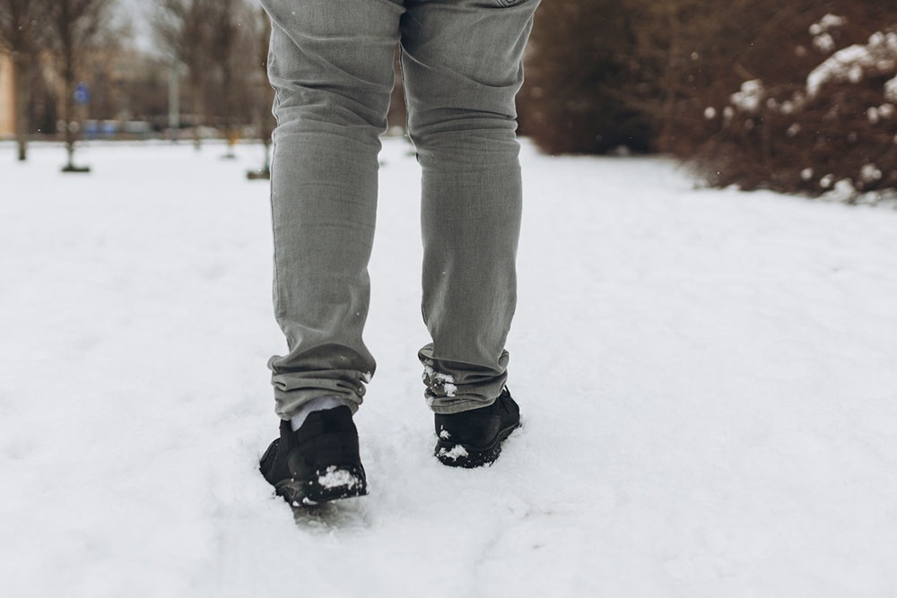 Ноги мужчины в тесной обуви и узких брюках