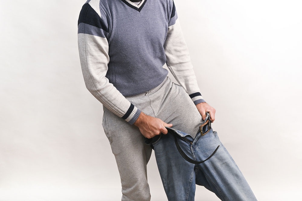 Мужчина надевает джинсы на термобелье