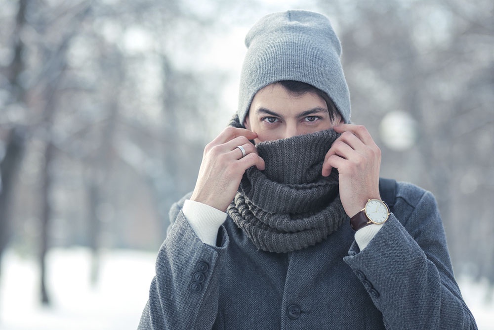 Мужчина надевает шарф снуд