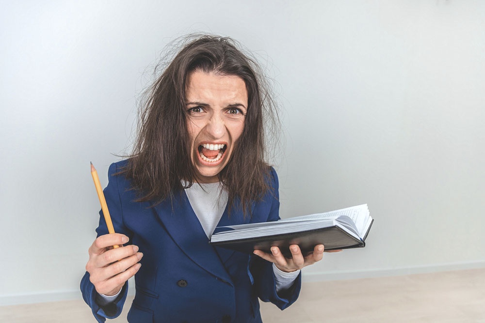 Женщина с дневником в руках выражает негативные эмоции, ведет дневник