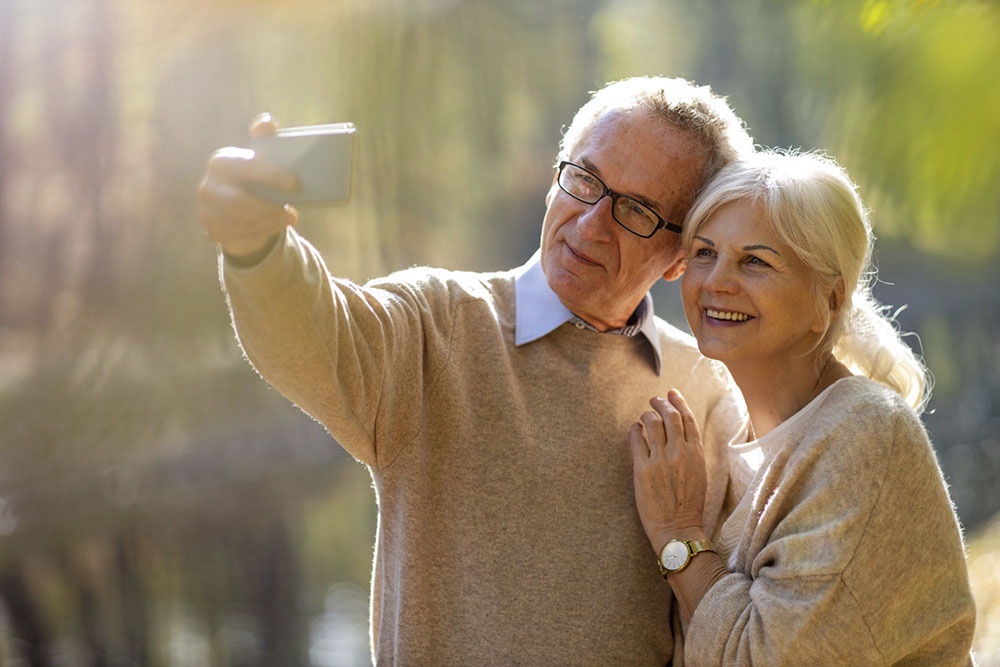 Пожилые и счастливые муж и жена делают селфи
