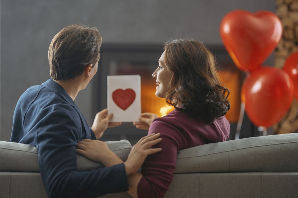 Муж дарит поздравительную открытку жене