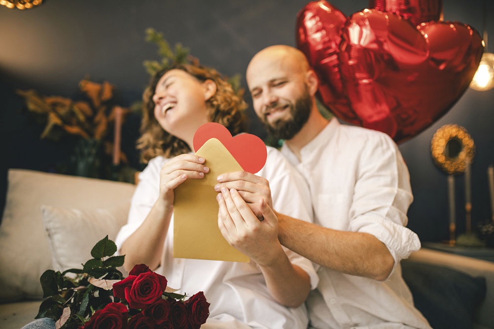 Муж дарит жене послание и сердечко - символ любви