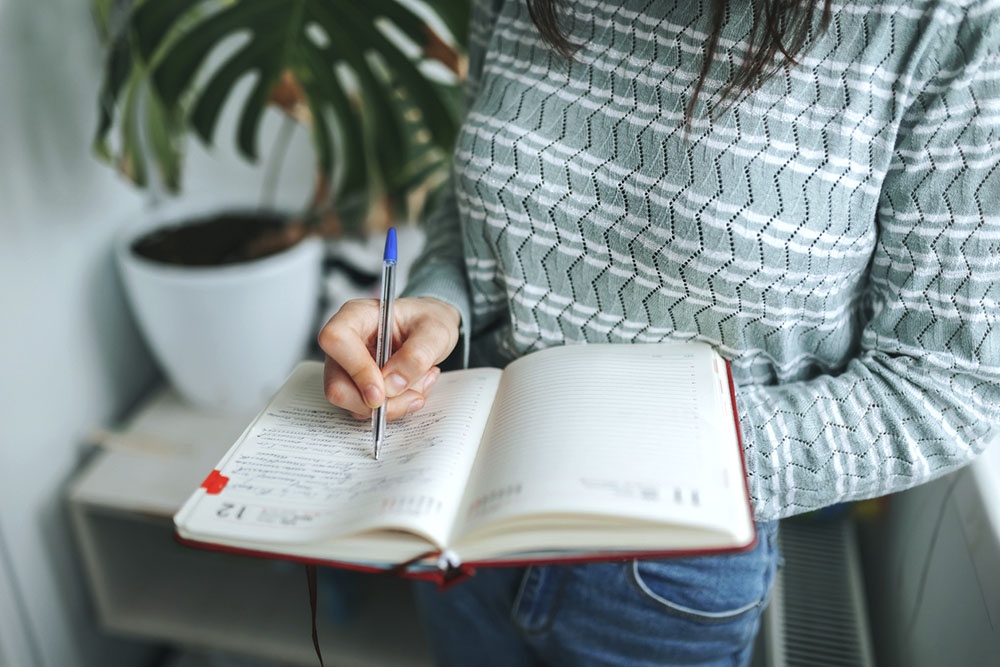 Девушка пишет заметки в дневник