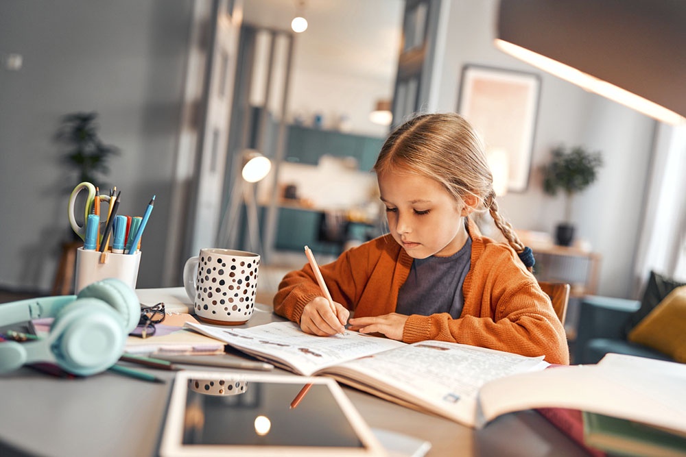 Девочка пишет и рисует в дневнике