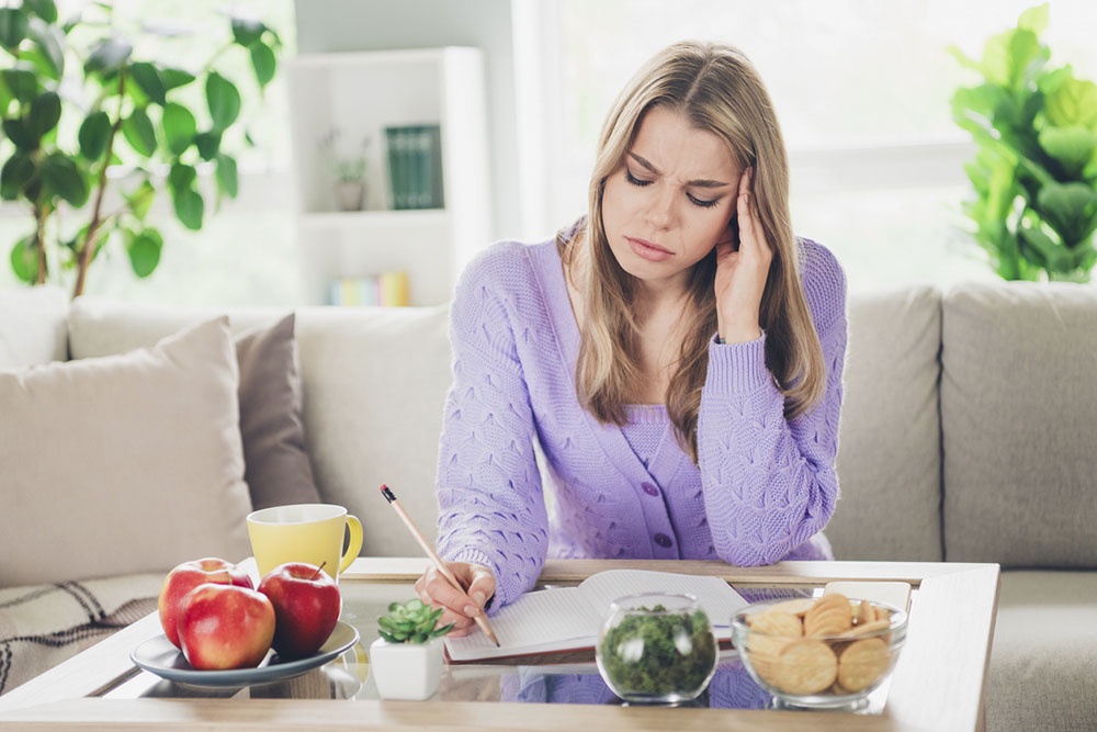 Девушка записывает свои мысли и эмоциональные переживания в дневник