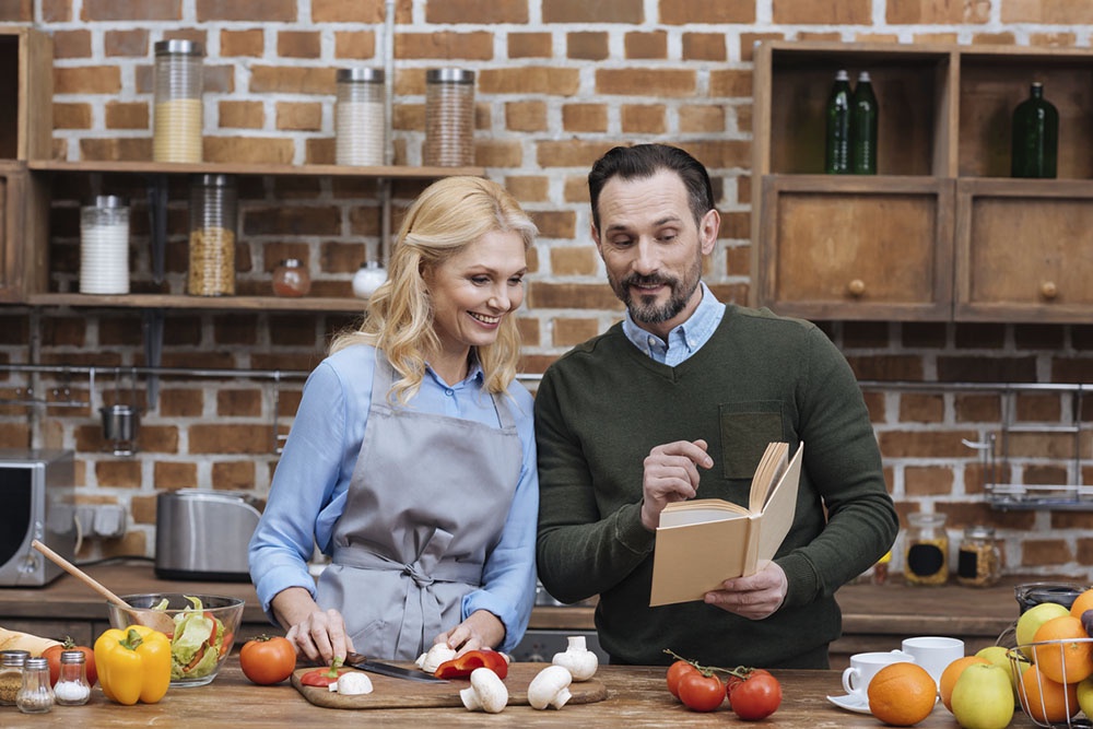 Муж и жена читают кулинарную книгу