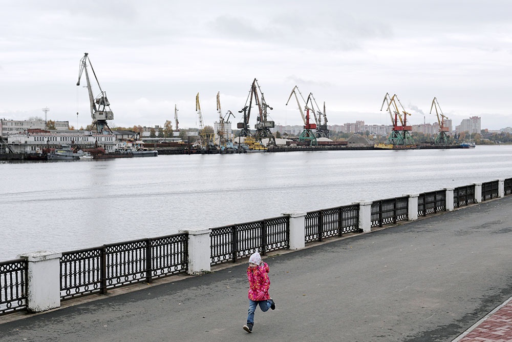 Девочка бежит по набережной реки Шексны в Череповце.