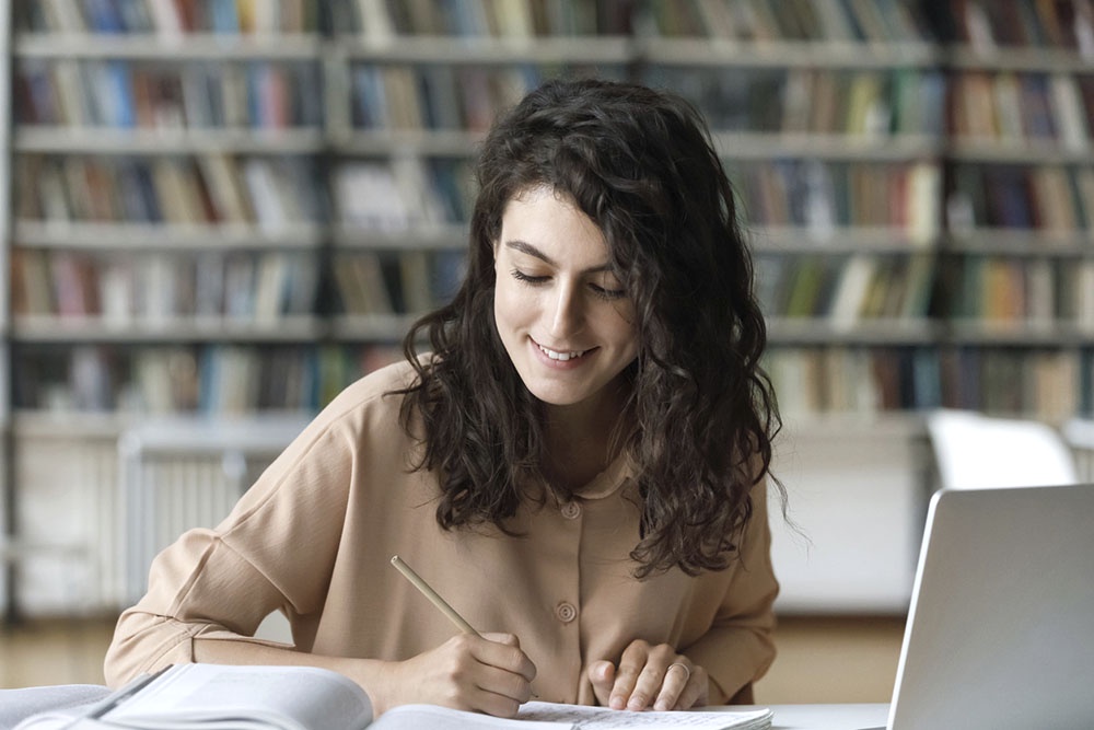 Девушка в библиотеке  пишет диссертацию