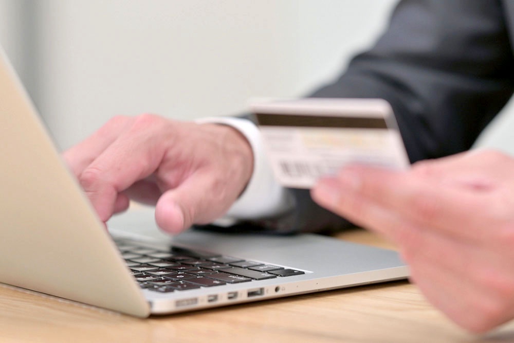 Человек совершает электронный платеж, досрочное погашение ипотеки.