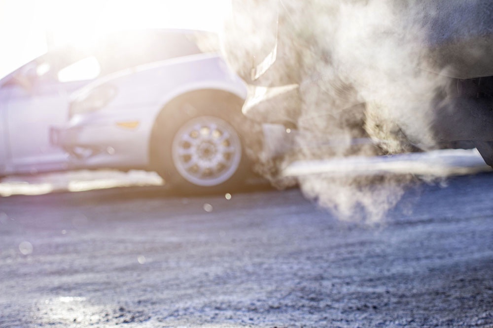 Машина зимой прогревается на автостоянке.