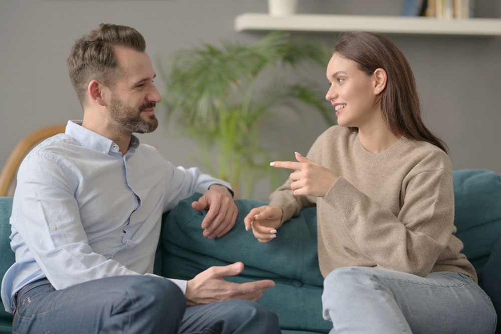 Мужчина и женщина разговаривают сидя на диване