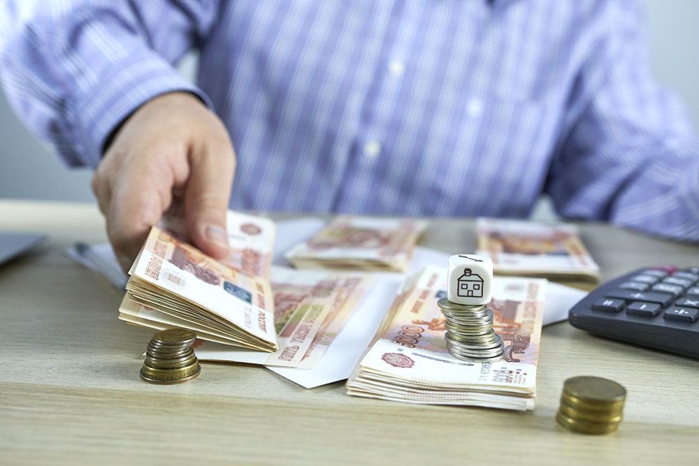 Человек считает наличные рубли. Концепт - рефинансирование ипотеки.