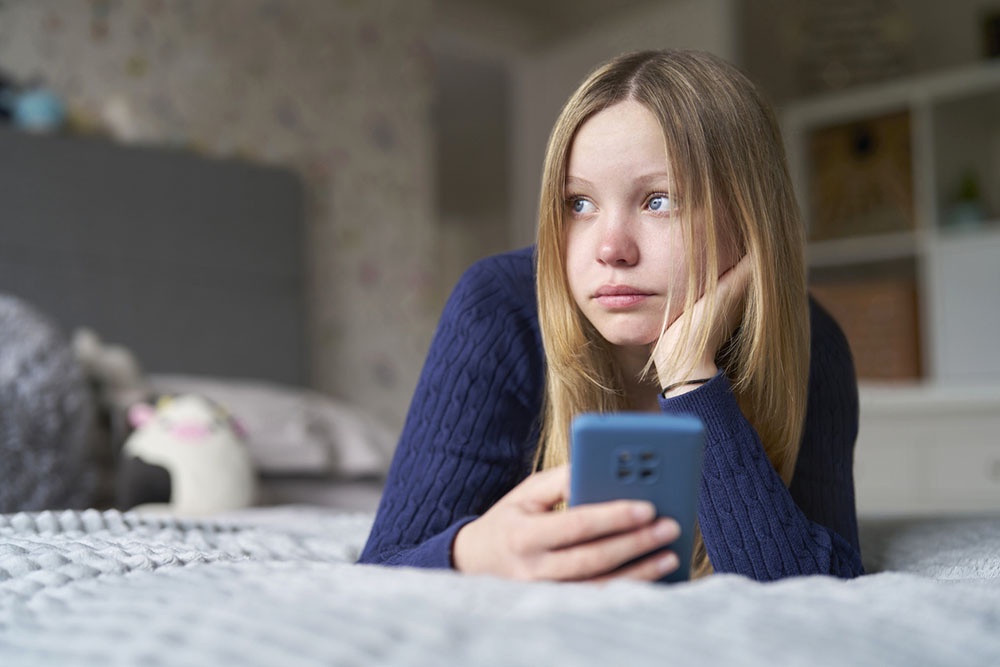 Молодая девушка с грустным и задумчивым видом переживает эмоциональные трудности и стресс, связанные с учебой и общением.