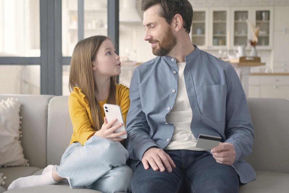 Дочь просит отца сделать покупку в интернете.