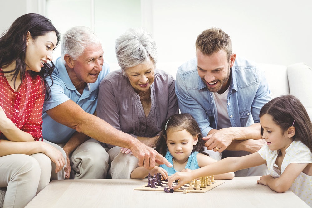 Семья собралась вместе, дети играют в шахматы.