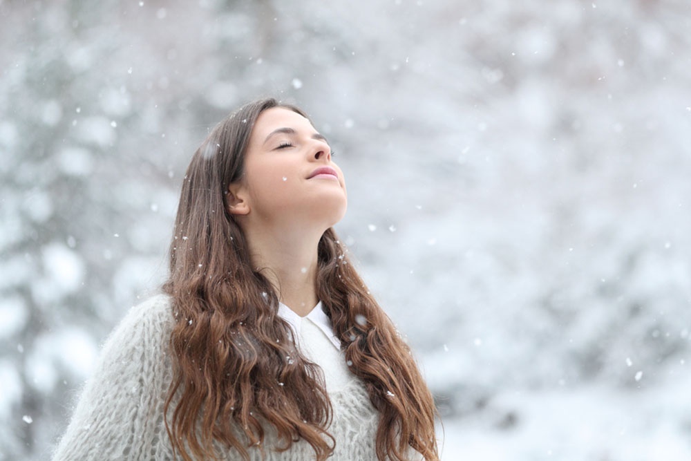 Девушка наслаждается спокойной прогулкой в зимнем лесу.
