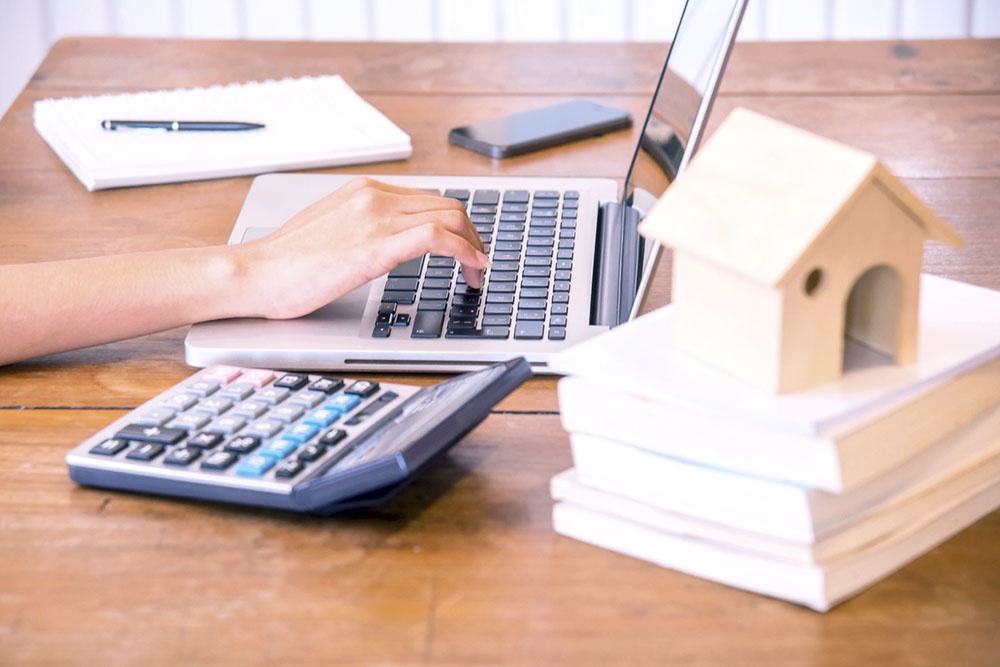 Человек вводит данные в поля онлайн-калькулятора ипотеки на ноутбуке.