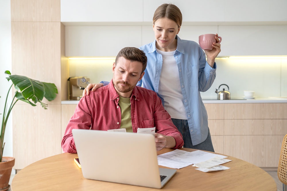 Молодая семья внимательно рассматривает и сравнивает разные страховые полисы, полученные при оформлении ипотечного кредита.