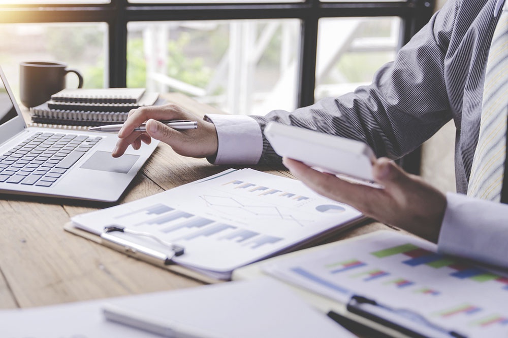 Человек изучает график платежей и процентные ставки по ипотеке, рассчитывая размер первоначального взноса.