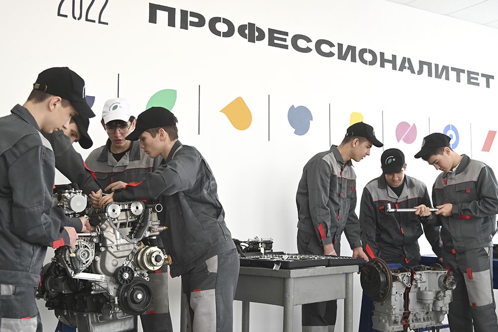 Студенты в лаборатории ремонта двигателей автомобилей в  многопрофильном техникуме.