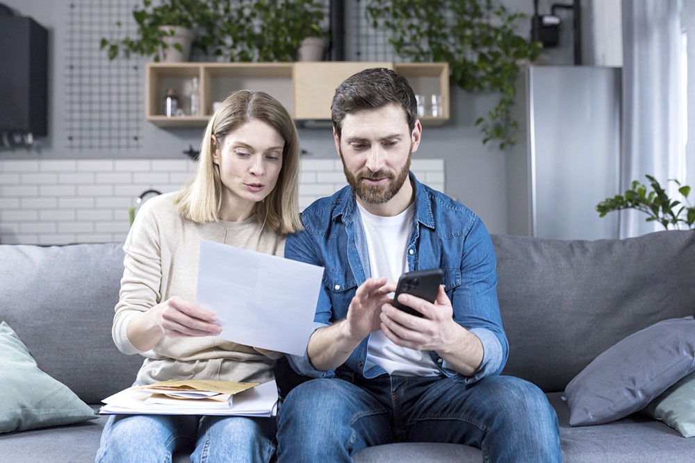 Супруги изучают документы на налоговый вычет дома, обсуждая его распределение.