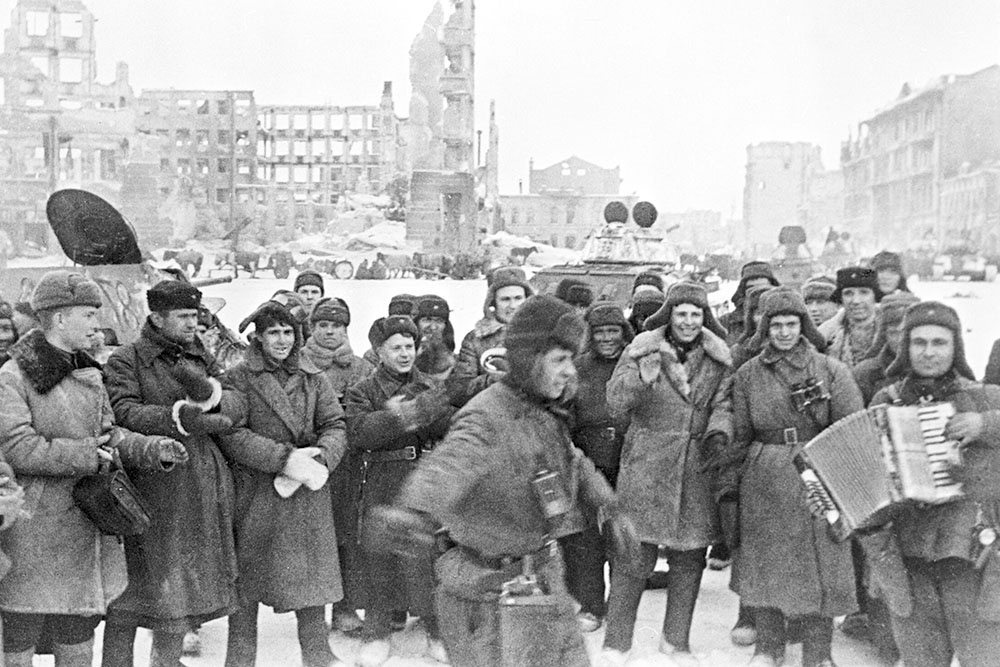 Красноармейцы с аккордеоном празднуют победу в Сталинградской битве на площади Павших борцов в освобожденном Сталинграде.