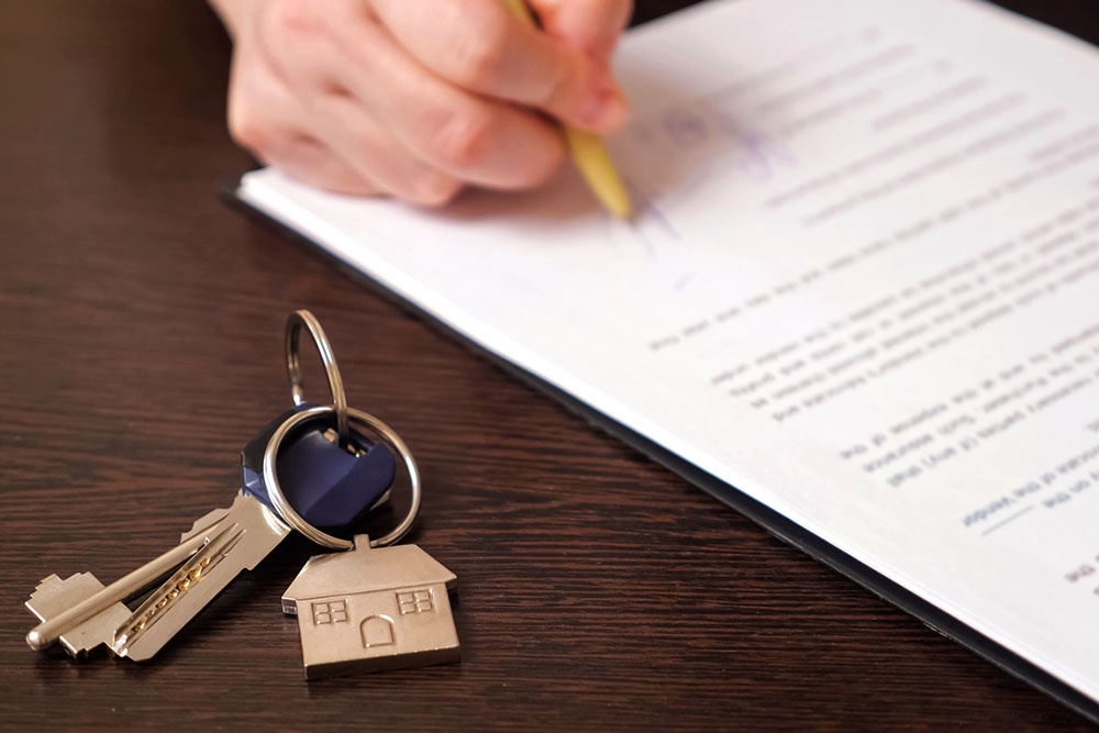 Документ о дарении доли в ипотечной квартире лежит рядом с ключами от кавртиры.