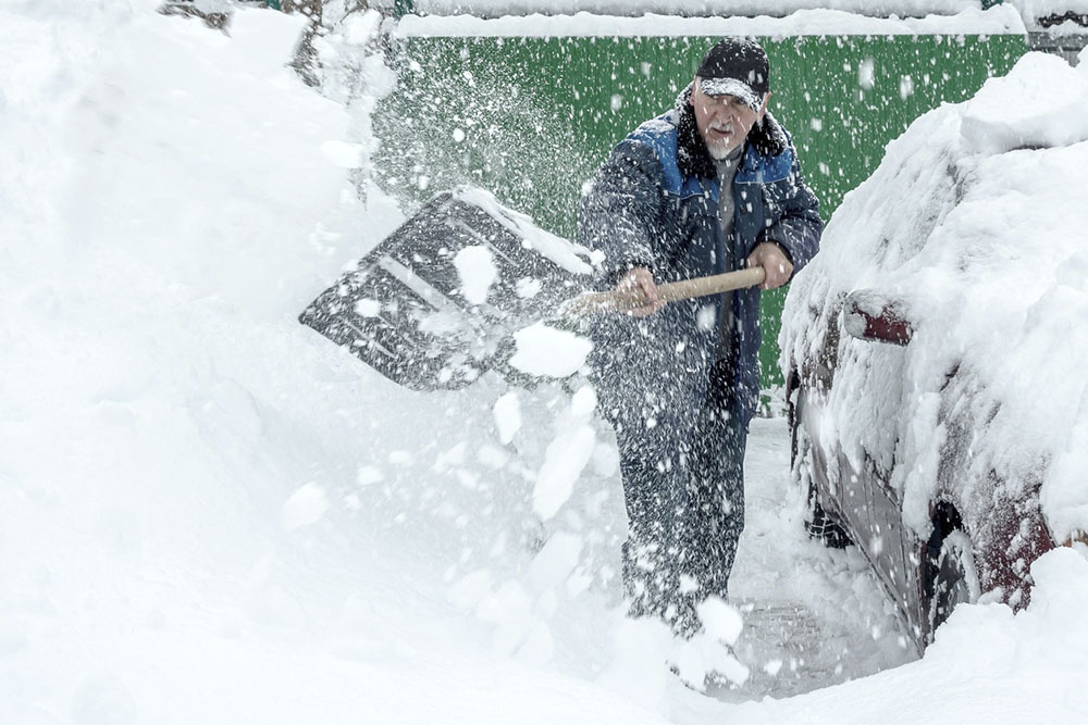 Человек демонстрирует технику уборки снега: резкий рывок и заброс.