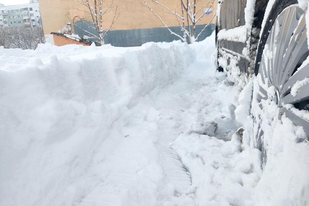 Очищенное от снега колесо и небольшой проход в сугробе.