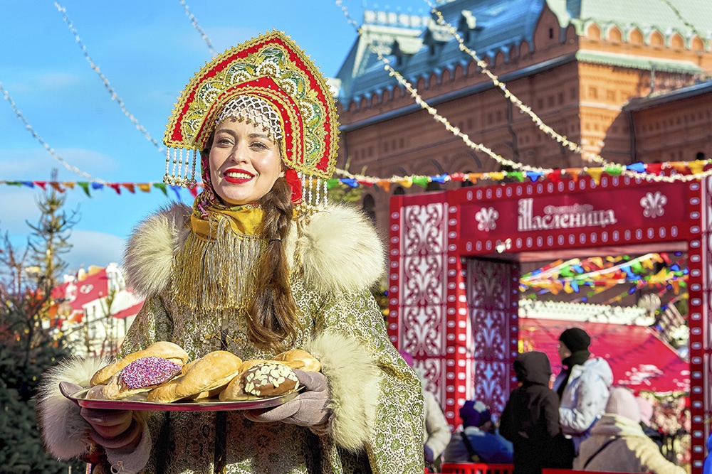 Масленица в Москве 2026, участница фестиваля с блинами.