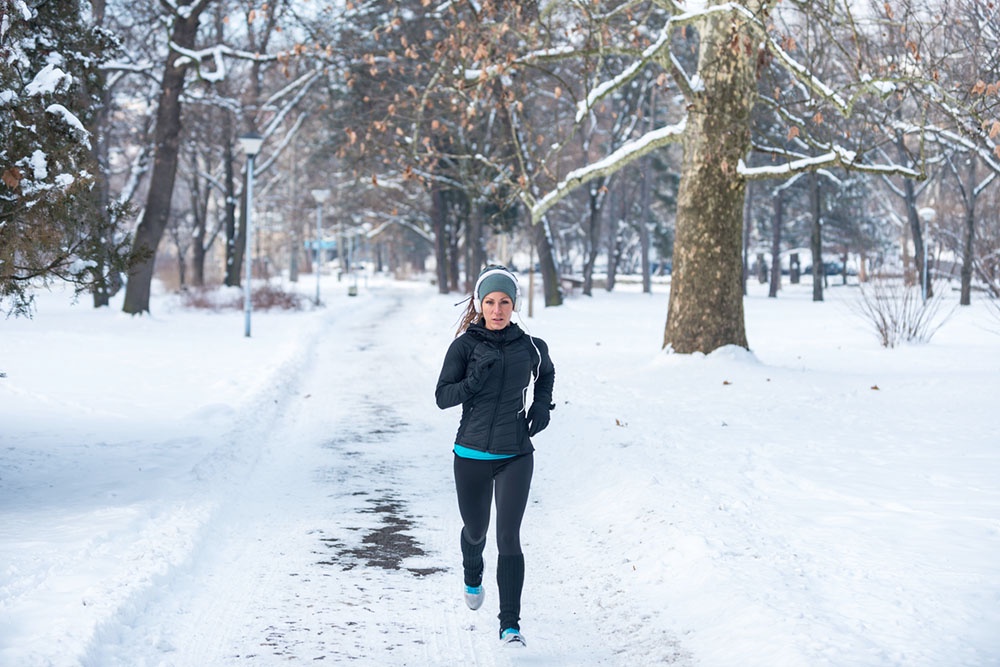 Девушка на утренней пробежrе в зимнем парке.