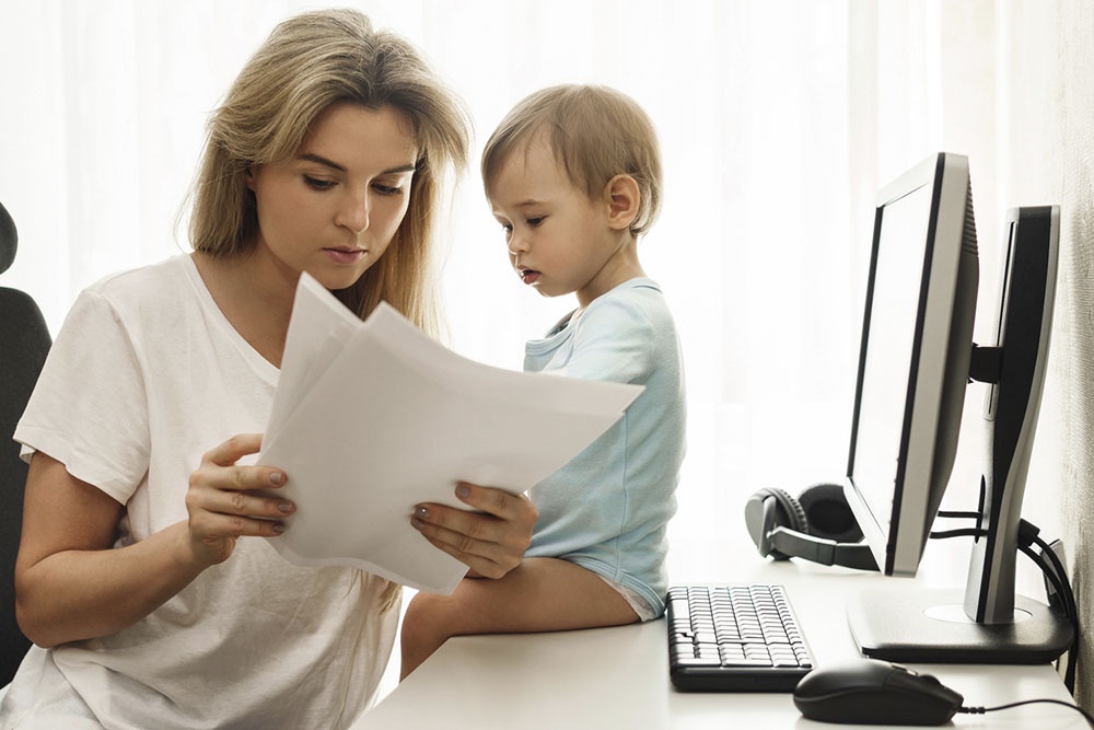 Женщина, мама с маленьким ребенком.  Изучает документы дома.
