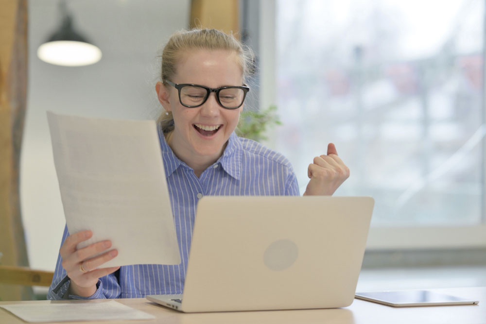 Школьница радостно проверяет результаты экзамена.