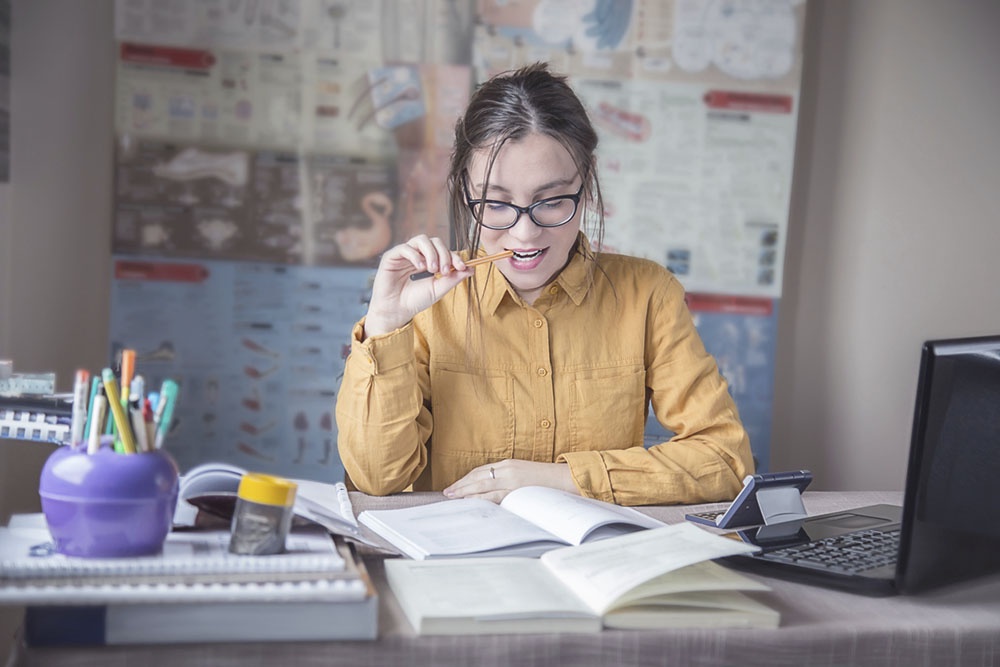 Школьница изучает материалы по биологии, подготовка к экзамену.