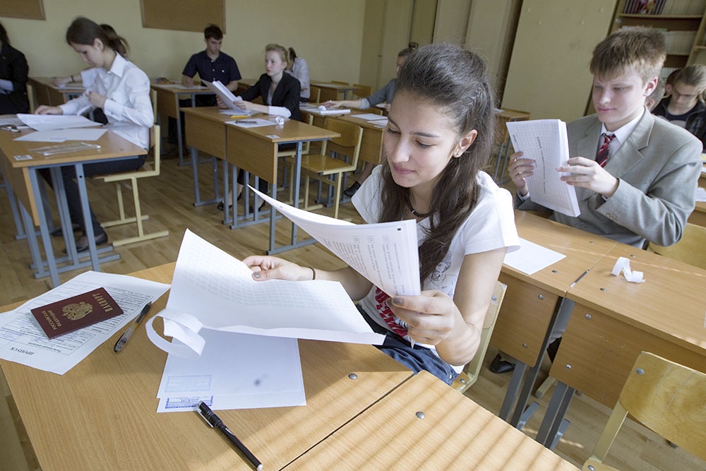 Школьники на экзамене, изучают бланки заданиями.