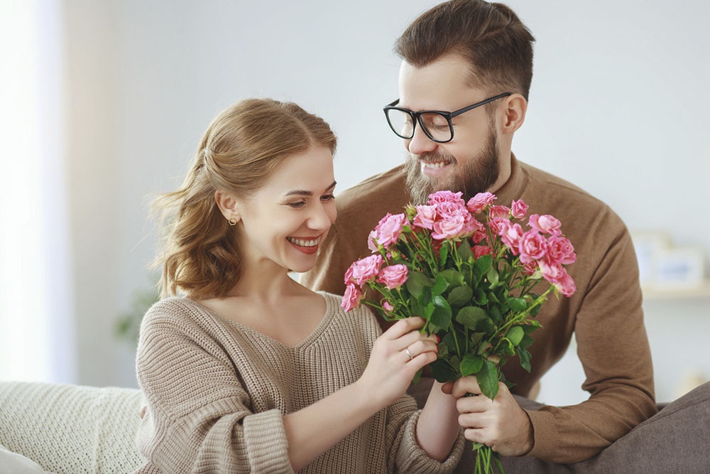 Мужчина дарит женщине цветы.