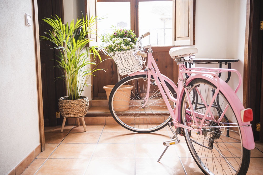 Старый велосипед украшен цветами в интерьере дачи.