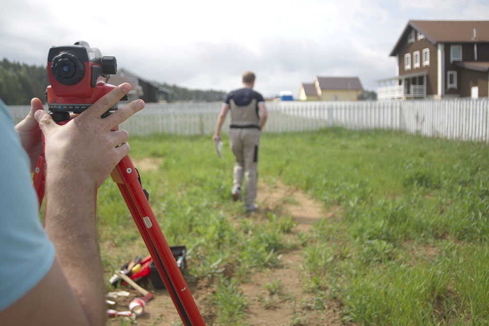 Работники  производят замеры на участке.