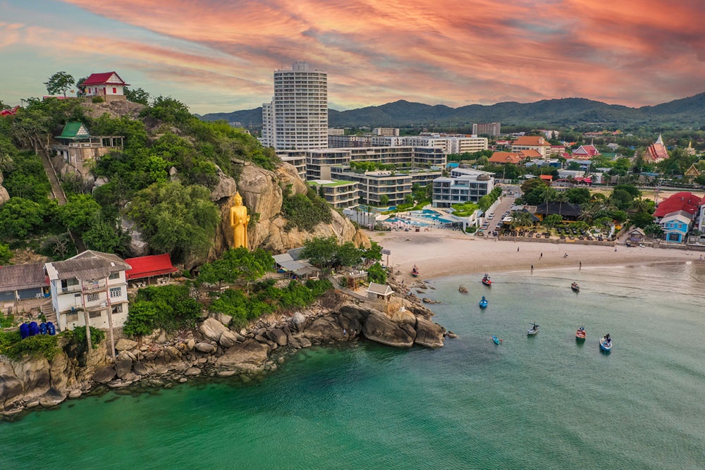 Холм в Хуа Хин, Таиланд. Живописный вид на храм на вершине холма, песчаный пляж и бирюзовые воды залива.