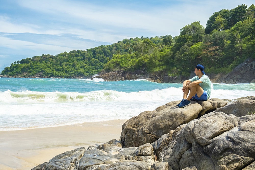 Мужчина-турист отдыхает на пляже Фридом - одном из живописнейших мест Пхукета. 