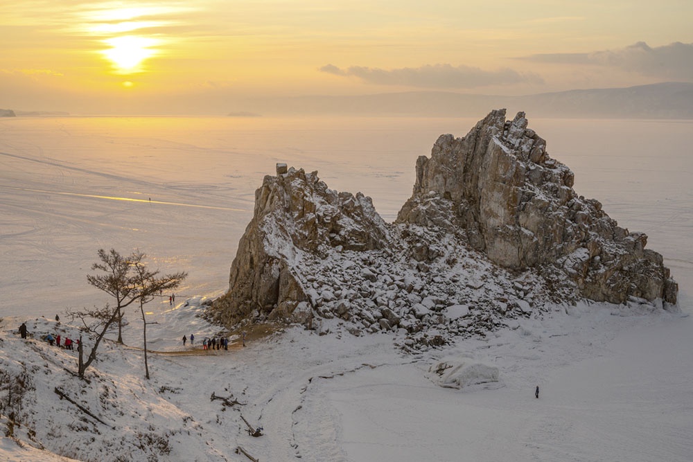 Шаманская скала на замерзшем озере Байкал зимой в Сибири, Россия, в лучах заходящего солнца. 