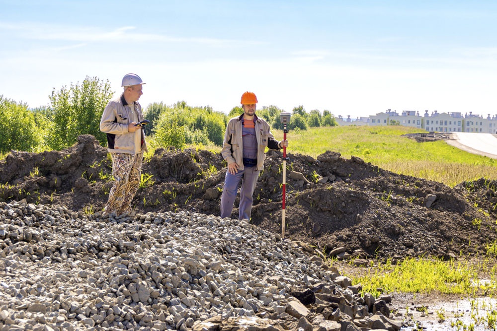 Работники изучают грунт на участке.