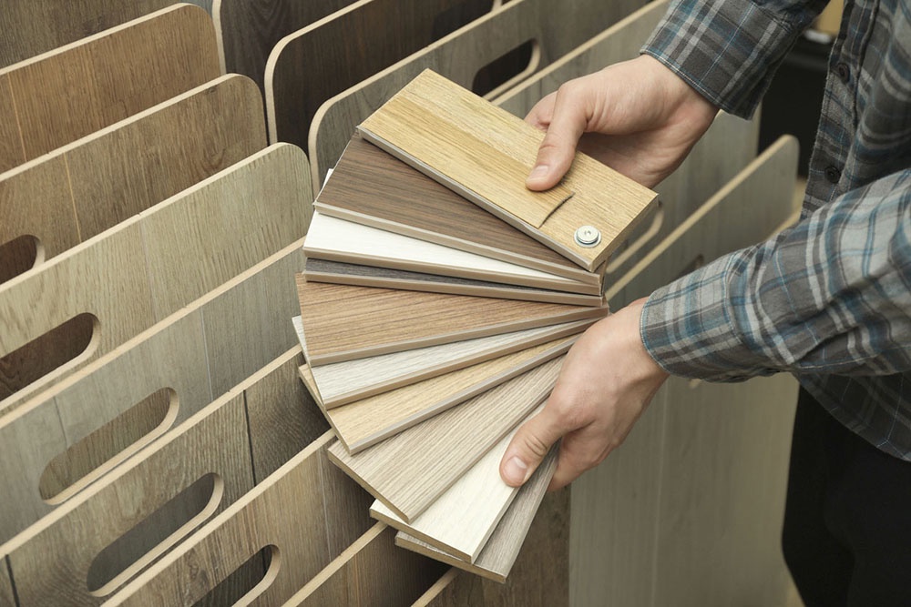 Человек выбирает напольное покрытие.