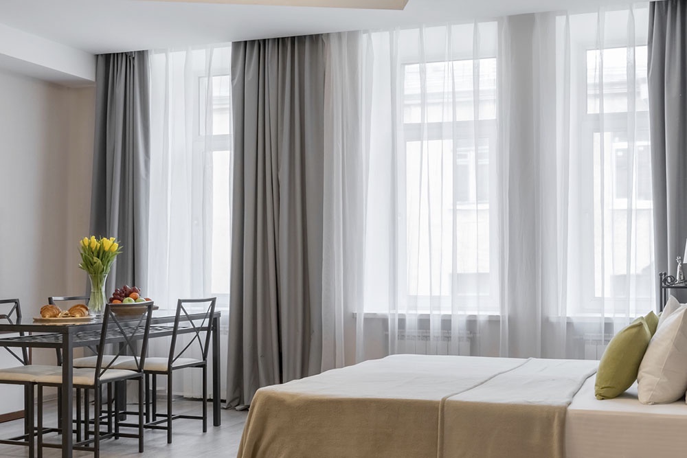 Интерьер современной гостиной с серыми шторами.