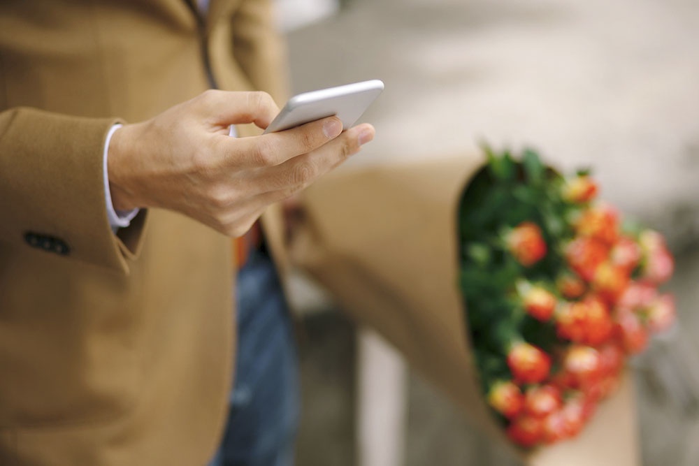 Мужчина пишет сообщение, смс поздравление с 8 марта.