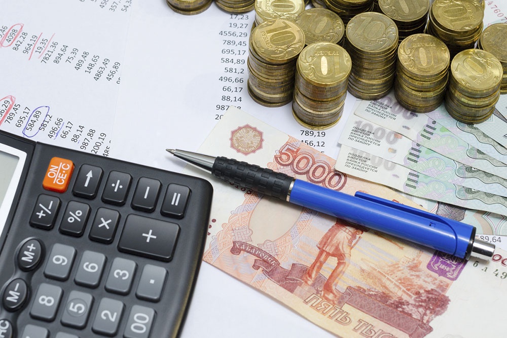 Деньги и расчетный листок с платежами по ипотеке.