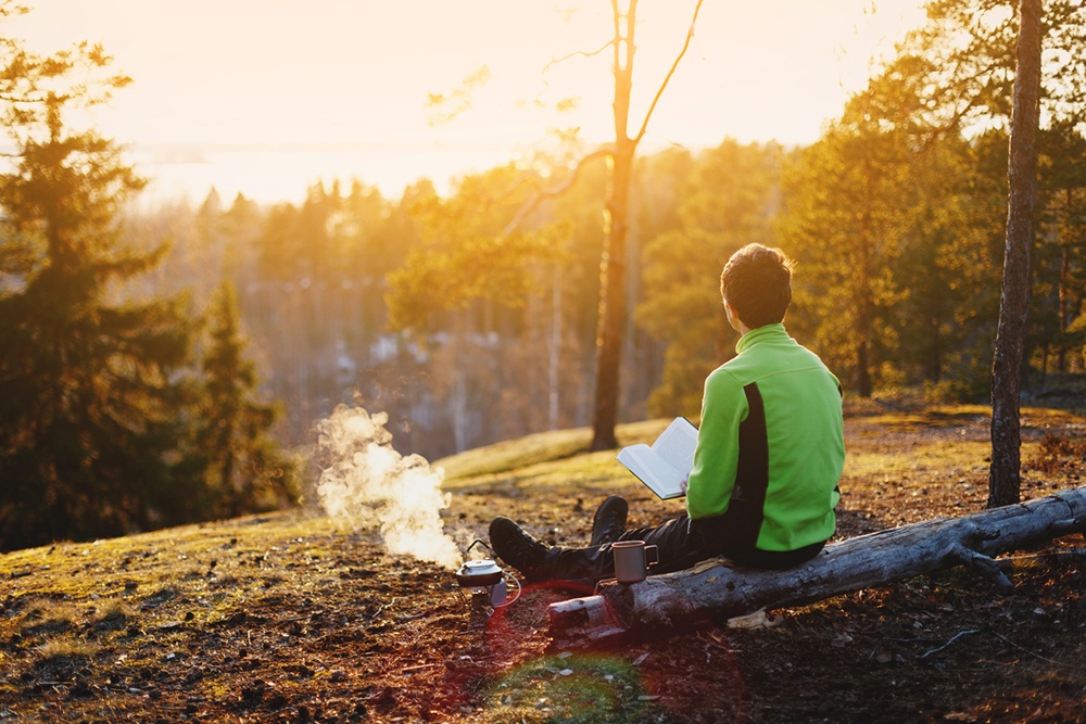 Человек на природе, наблюдает за закатом.