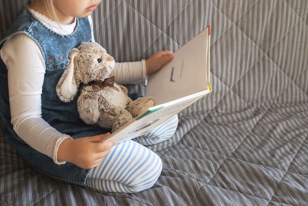 Девочка читает книгу.